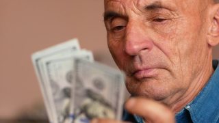 老年人与金融主题。一名70多岁的白人老人在数钞票。退休年龄，退休金分配。爷爷手里有美元。有选择性的重点,视频素材模板下载