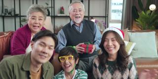 快乐的圣诞感恩节周末，多代亚洲家庭拜访祖父母坐在一起放松大笑微笑乐趣和快乐的美妙时刻在家里客厅，pov亚洲家庭在一起