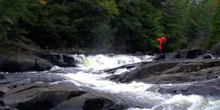 男子徒步在森林，河流和瀑布秋天森林自然，魁北克省，加拿大