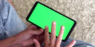 近景女孩的智能手机看着绿色的屏幕，手机上慢慢地滑动到一边，按查看chroma键在线文本输入阅读社交网络游戏互联网