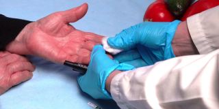 医生用针式血糖仪对糖尿病患者进行血糖测试，并检测其指尖血糖水平。糖尿病的医疗和治疗理念。