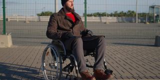 孤独的残疾人坐在轮椅上看着城市