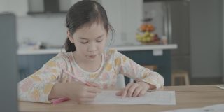 混合亚洲女孩在家里用笔记本电脑视频通话，使用缩放在线虚拟课堂，社交距离，在家上学，远程学习，新常态概念