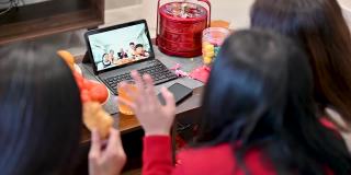 快乐的亚洲家庭在网上祝贺中国新年，并在家里通过数码平板电脑视频电话与亲戚团聚