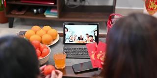 快乐的亚洲家庭在网上祝贺中国新年，并在家里通过数码平板电脑视频电话与亲戚团聚