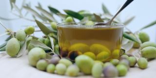丰富的季节性收获橄榄水果，勺子成熟橄榄水果和滴橄榄油在慢动作，有机橄榄油生产