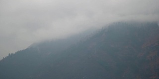 在喜马偕尔邦的马纳里，冬季浓雾笼罩的山峰。冬天被雪覆盖的山