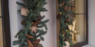 窗户上装饰着圣诞树、冷杉枝、装饰物和花环灯