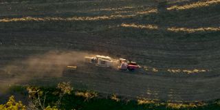 自顶向下的空中跟踪拖拉机捆玉米秸秆在农村宾夕法尼亚州，美国