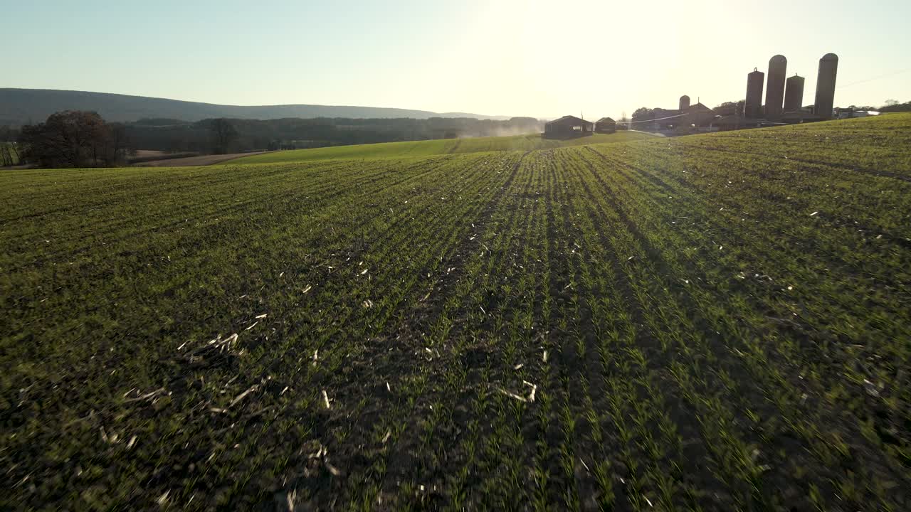 高空覆盖作物幼苗和路过的拖拉机在宾夕法尼亚州农村，美国