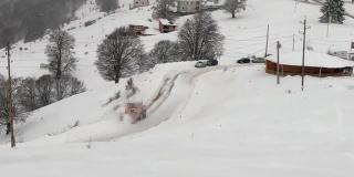 用扫雪机扫雪车梳理雪和清扫道路在暴风雪期间，滑雪冬季度假胜地。重型机械山地设备履带车