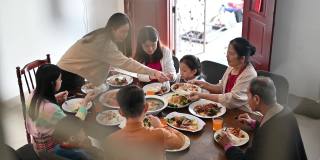 欢乐的亚洲三代家庭在春节期间在家里庆祝和享受团圆饭