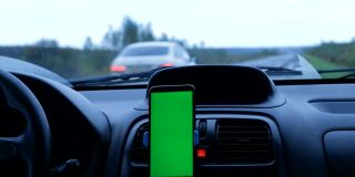 绿色屏幕手机的内容嵌入安装在面板内的汽车停在道路上
