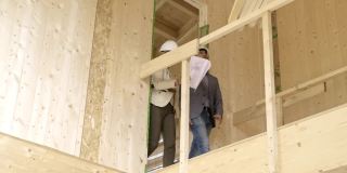 女建筑师和建筑工人在建筑工地修正建筑计划