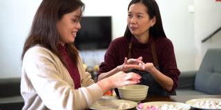 两位亚洲妇女正在做汤圆，作为中国新年的团圆饭