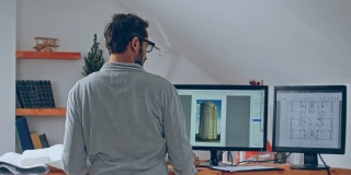 在一个高层建筑项目中，一个戴着眼镜的男人在一台笔记本电脑和另外两台显示器上工作。使用远程方案在家工作的概念。检疫