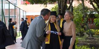 毕业典礼后，自豪的父母拥抱着他们的女儿，微笑着和她交谈