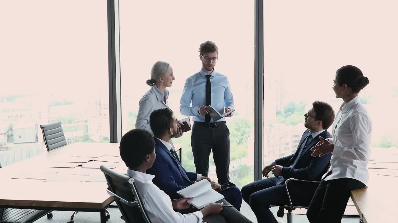 不同的员工在办公室的晨会上讨论议程