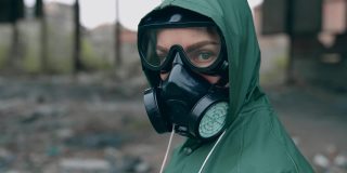 环境污染和生物危害。一个戴防毒面具的人在废弃建筑附近