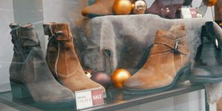 鞋店橱窗里的货架上摆放着各种颜色的经典皮女鞋，上面还贴着价格标签