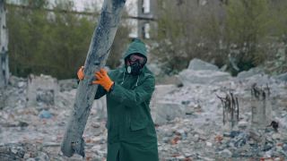 戴防毒面具的人在废墟上。穿着防护服，带着防毒面具的男子正在废墟中行走视频素材模板下载