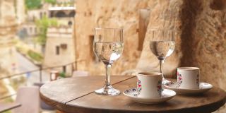 2021年9月15日，土耳其，哥尔梅:在卡帕多西亚的传统洞穴咖啡馆里，女性手拿着一杯白色的土耳其咖啡