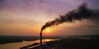 来自工业管道的危险空气污染。农村的发电厂在日落时产生有害烟雾。空气排放污染概念。