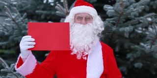 快乐的圣诞老人穿着圣诞帽的服装拿着复制空间红色空白的标志