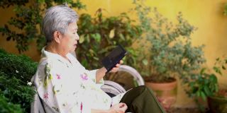 亚洲老人，亚洲老人，年长的老妇人在户外用智能手机聊天