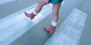 穿棕色靴子的女士行人在人行横道过马路