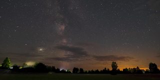 在布满星星的夜空中，银河在雾气弥漫的田野上移动的时间间隔。时间的推移，星空与云