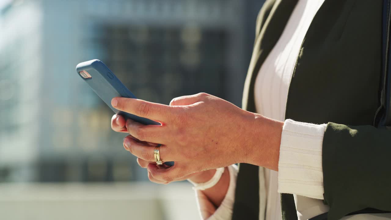 一名女商人在城市里使用智能手机的4k视频
