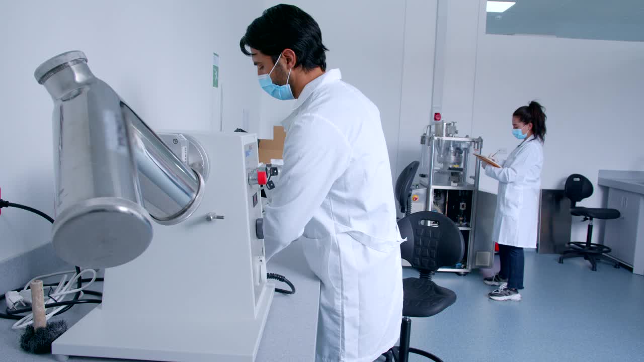 拉丁美洲男性研究人员在实验室调整机器的医学样本