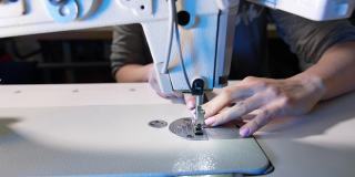 妇女用现代缝纫机工作。纺织厂的衣服。