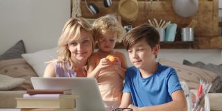快乐的家庭在家里，母亲和儿子和女儿玩电脑，父母和孩子在笔记本电脑上浏览互联网，男孩学生在显示器上显示一些东西