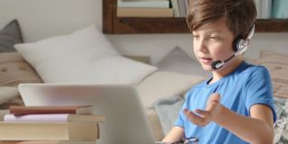 专注的学生男孩在网上远程学校的电脑上学习，浏览和搜索互联网或其他活动，如社交媒体或在线游戏或娱乐的概念