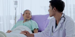 亚洲男医生交谈和安慰在床边的老年病人。