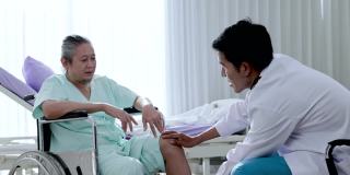 整形外科亚洲男医生坐在轮椅上检查患者的膝盖。