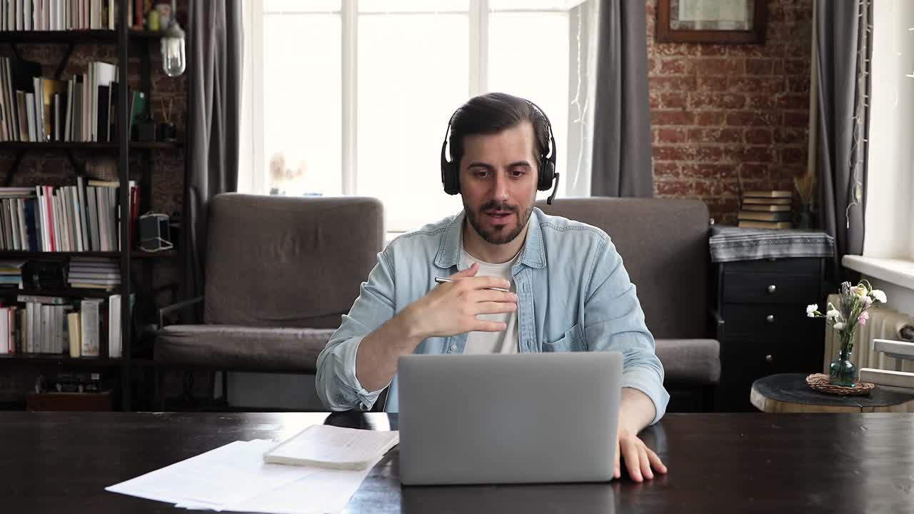男子在耳机电子学习使用笔记本电脑与在线导师沟通