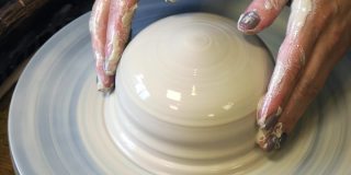 在制陶轮上使用粘土坯时，手所施加的压力