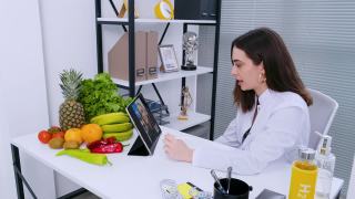 营养学家使用数码平板电脑对她的病人进行在线咨询视频素材模板下载