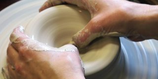 用手指在陶工轮上膨胀粘土坯的内径