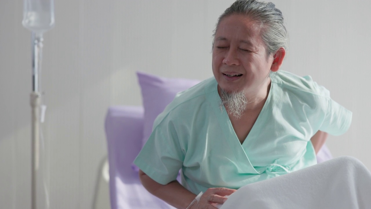 在医院的病房里，一位亚洲老年男性病人躺在床上。
