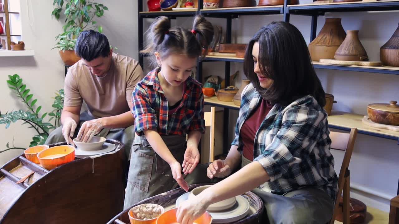 妈妈向女儿展示在陶工转盘上工作的技巧
