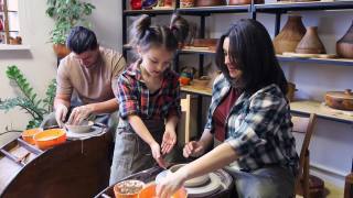 妈妈向女儿展示在陶工转盘上工作的技巧视频素材模板下载