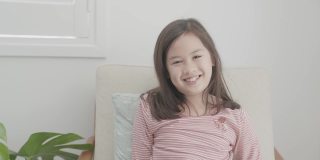 混合亚洲女孩在家里与数字平板电脑视频通话，使用缩放在线虚拟课堂，社交距离，在家上学，电子学习，新常态概念