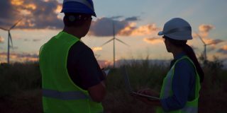 两名亚洲工程师检查工程师准备和进度检查在泰国风电场的一个风力涡轮机的安全。