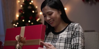 一名亚洲日本妇女对自己的圣诞礼物感到失望，在晚上的节日庆祝活动中，她强迫自己微笑，假装高兴