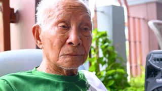 一个九十多岁的亚洲人坐在家里，在他的辛苦工作中放松他的一生。视频素材模板下载