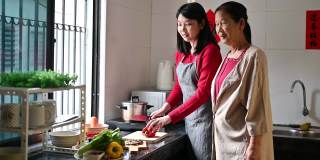 一位亚洲的祖母和她的孙女在为他们的年夜饭准备食物
